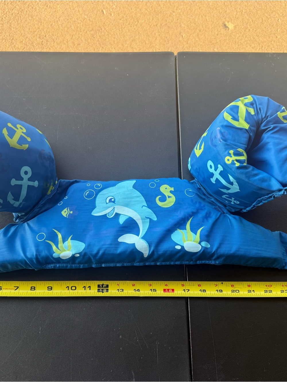 Blue arm floaties with white dolphin, yellow anchors and seaweed graphics